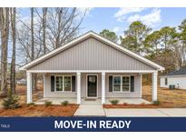 Charming single-story home featuring a covered front porch, gray siding, and landscaped front yard at 307 E Pope Ave, Kenly, NC 27542