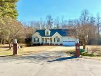 Suburban home with landscaped yard, two-car garage, and brick accents at 414 Ash Lily Ct, Nashville, NC 27856