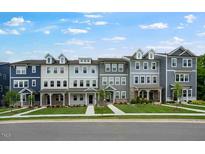 Charming street view of townhomes with well-manicured lawns and inviting entryways at 433 Rowe Way, Knightdale, NC 27545