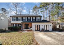 Two-story house with white siding, black shutters, and a brick front at 5315 Oakbrook Dr, Durham, NC 27713