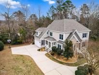 An elegant two-story home boasting a long driveway, mature trees and meticulously maintained landscaping at 7416 Capulin Crest Dr, Apex, NC 27539