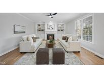 Bright living room with fireplace, built-in shelves and hardwood floors at 109 Aspenridge Dr, Holly Springs, NC 27540