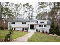 White charming one-story home with a well-manicured lawn at 128 Bruce Dr, Cary, NC 27511