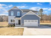 Two-story house with blue siding, stone accents, and a two-car garage at 148 Aylebury Rdg, Zebulon, NC 27597