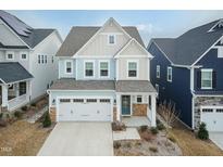 Two-story light blue house with white garage door and stone accents at 2371 Kettle Falls Sta, Apex, NC 27502