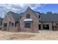 Brick exterior showcasing classic design elements and large windows at 274 Westhampton Dr, Pittsboro, NC 27312