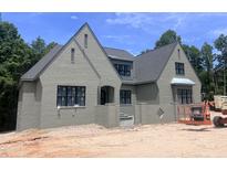 Beautiful two-story home featuring a painted brick facade, black window frames, and a gabled roof design at 274 Westhampton Dr, Pittsboro, NC 27312