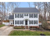 Two-story white house with black shutters, landscaping, and a driveway at 2817 Hiking Trl, Raleigh, NC 27615