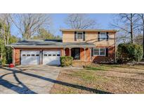 Brick ranch house with attached two-car garage and a well-manicured lawn at 3042 Marlborough Rd, Burlington, NC 27215