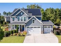 Two-story house with gray siding, solar panels, and a three-car garage at 316 Granite Cove Ct, Rolesville, NC 27571