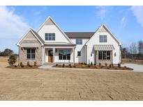 Striking two-story home with stone accents and a meticulously landscaped yard at 4912 Hidden Pasture Way, Zebulon, NC 27597