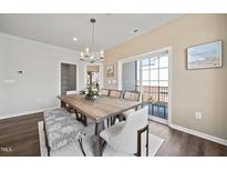 Bright dining room features a wood table, bench, and chairs, with access to a balcony at 604 Market Grove Dr # 200, Wake Forest, NC 27587