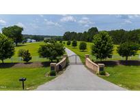 Gated driveway leading to a stately home on a sprawling, well-manicured lawn at 14425 Nc-96 N Hwy, Zebulon, NC 27597