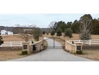 Brick pillars and wrought iron gates open to a long driveway leading to a beautiful home at 14425 Nc-96 N Hwy, Zebulon, NC 27597