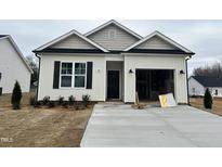 Inviting single-story home with a welcoming entrance, gray accents and attached two-car garage at 150 W Saltgrass Ln, Smithfield, NC 27577