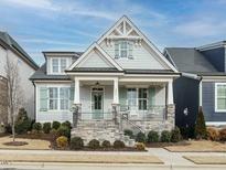 Craftsman style home with gray siding, light green shutters, and a stone front porch at 1572 Lone Prairie Dr, Wendell, NC 27591