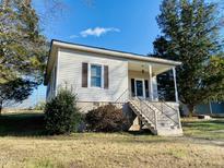Tan colored house with front porch and steps leading to the entrance at 1716 Turner St, Roxboro, NC 27573