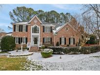 Two-story brick home with a large front yard and snow at 206 Joseph Pond Ln, Cary, NC 27519