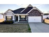 Charming single-Gathering home with a manicured lawn and attached two-car garage at 256 Barbour Farm Ln, Four Oaks, NC 27524