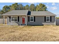 Gray house with red door, stone pathway, and small yard at 4104 Ludgate Dr, Durham, NC 27713