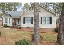 Beige house with gray roof, brick base, and black shutters at 4209 Medlar Ln, Raleigh, NC 27616