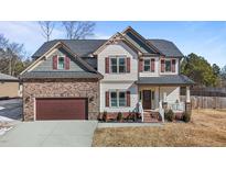 Two-story house with stone and shingle accents, double garage, and landscaping at 467 Joseph Alexander Dr, Fuquay Varina, NC 27526