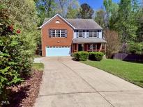 Charming two-story home with a brick facade, attached garage, and a well-manicured front yard at 6645 Austin Creek Dr, Wake Forest, NC 27587
