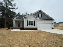 Charming single-Gathering home with a two-car garage, landscaped lawn and a welcoming front porch at 100 Preacher Ln, Angier, NC 27501