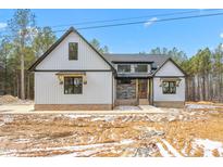 Stunning farmhouse exterior with gray siding and stone accents at 1040 Southern High School Rd, Burlington, NC 27215
