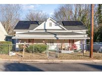 Charming white house with solar panels and a covered porch at 1105 Carroll St, Durham, NC 27707