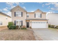 Charming two-story home features a spacious two-car garage, black shutters, and a well-manicured front yard at 112 Smith Rock Dr, Holly Springs, NC 27540