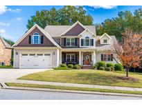 Two-story house with neutral siding, a three-car garage, and a landscaped yard at 1294 Fieldtrial Cir, Garner, NC 27529