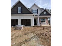 Charming home featuring a spacious two-car garage and a covered front porch, set against a bright sky at 35 Hewitt Wds Dr, Clayton, NC 27527