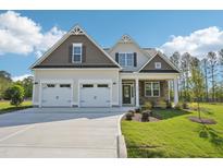 Charming two-story home boasts a manicured lawn, a two car garage, and welcoming stone accents on the porch at 35 Hewitt Wds Dr, Clayton, NC 27527
