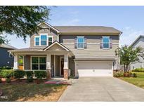Two-story house with gray siding, brick accents, and a welcoming front porch at 4052 Truelove Dr, Apex, NC 27539