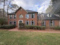 Brick house with gray shutters, landscaping, and a walkway at 704 Misty Isle Pl, Raleigh, NC 27615