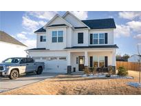 Two-story house with white siding, stone accents, and a two-car garage at 8 Looping Horse Cir, Angier, NC 27501