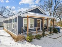 Charming home featuring a covered front porch, snow accents, and modern design at 819 Cumberland St, Raleigh, NC 27610