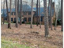 Brick house with dark gray roof, surrounded by tall trees at 14236 Wyndfield Cir Cir, Raleigh, NC 27615