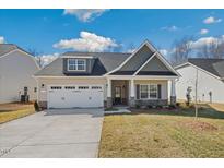 Charming single-Gathering home featuring a two-car garage, well-maintained lawn, and inviting front porch at 1975 Meadowview Dr, Graham, NC 27253