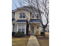 Two-story townhome with neutral siding, a front porch, and landscaping at 4202 Cherry Blossom Cir, Durham, NC 27713