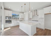 Bright kitchen features white cabinets, quartz counters, stainless appliances, and a large center island at 4717 Cypress Tree Ln, Raleigh, NC 27612