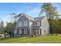 Two-story gray house with stone accents and a landscaped lawn at 80 Summer Mist Ln # 165P, Clayton, NC 27527