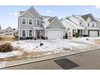 Two-story house with gray siding, a white garage door, and a snow-covered lawn at 803 Golden Plum Ln, Zebulon, NC 27597