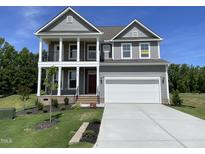 Inviting two-story home featuring a covered porch and a two-car garage, providing comfortable and stylish living at 85 N Stagecoach Dr, Wendell, NC 27591