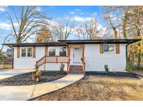 Charming ranch home with white exterior, wood accents, and landscaped yard at 919 Fiske St, Durham, NC 27703