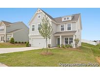Two-story house with gray siding, a two-car garage, and a front porch at 104 S Buggy Dr # 72P, Benson, NC 27504