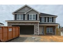 Charming two-story home featuring a stone facade, gray siding, and a spacious two-car garage at 107 Northwood Dr, Fuquay Varina, NC 27526