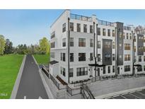 Beautiful three-story townhouse with rooftop terrace, black framed windows, and manicured landscaping at 111 Ailey Brook Way # 200, Wake Forest, NC 27587