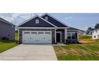 Charming single-Gathering home with stone accents, a two-car garage, and a well-maintained front lawn at 121 Northwood Dr, Fuquay Varina, NC 27526